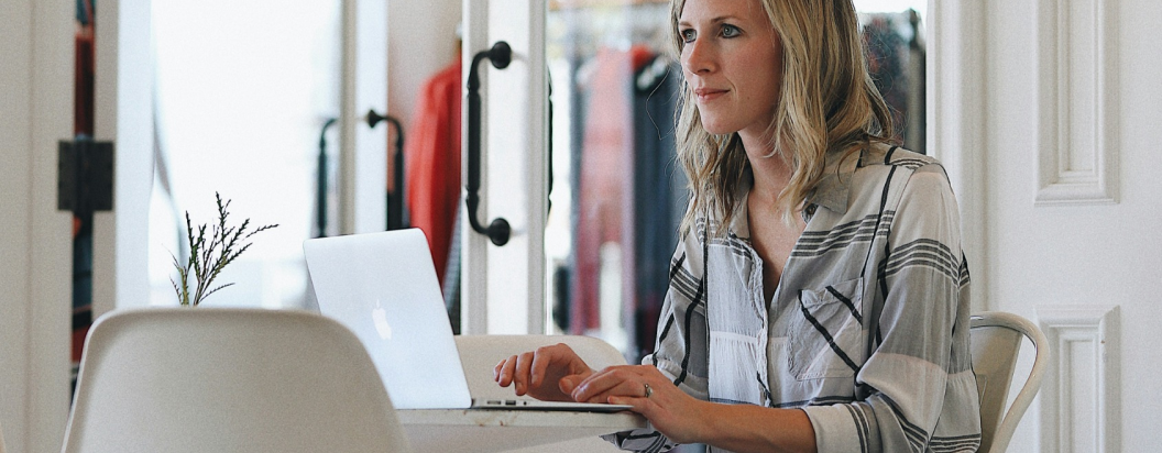 Imagem ilustrativa de uma mulher com um notebook navegando na plataforma da Fair Fashion